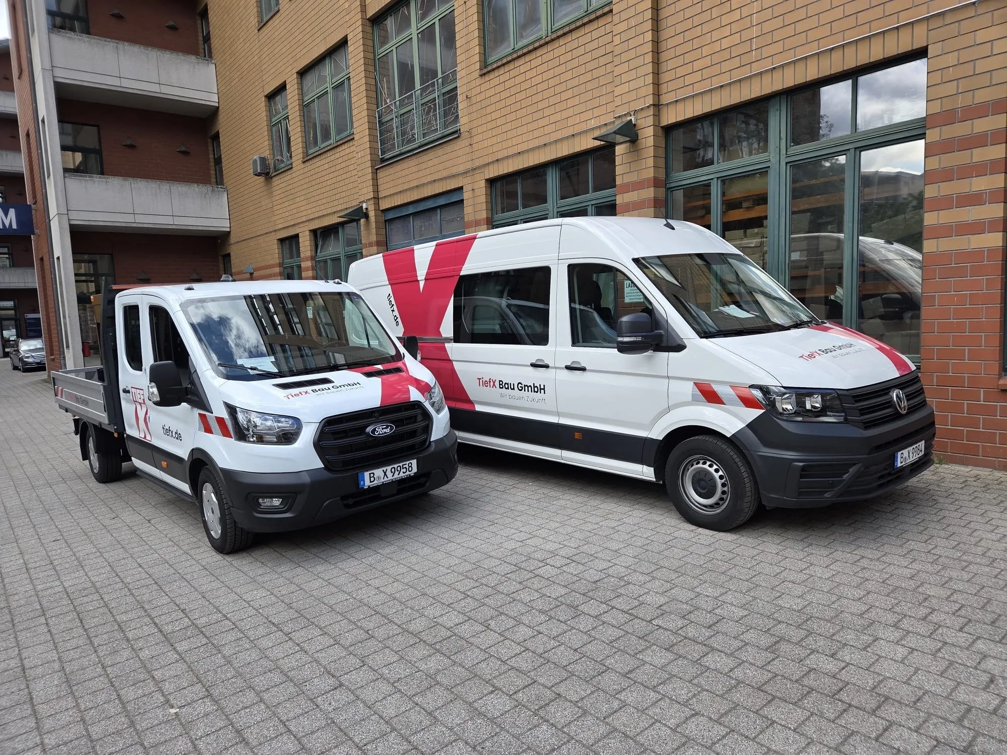 Pritschenwagen und Kastenwagen im TiefX-Design vor dem Firmensitz in Berlin-Marzahn