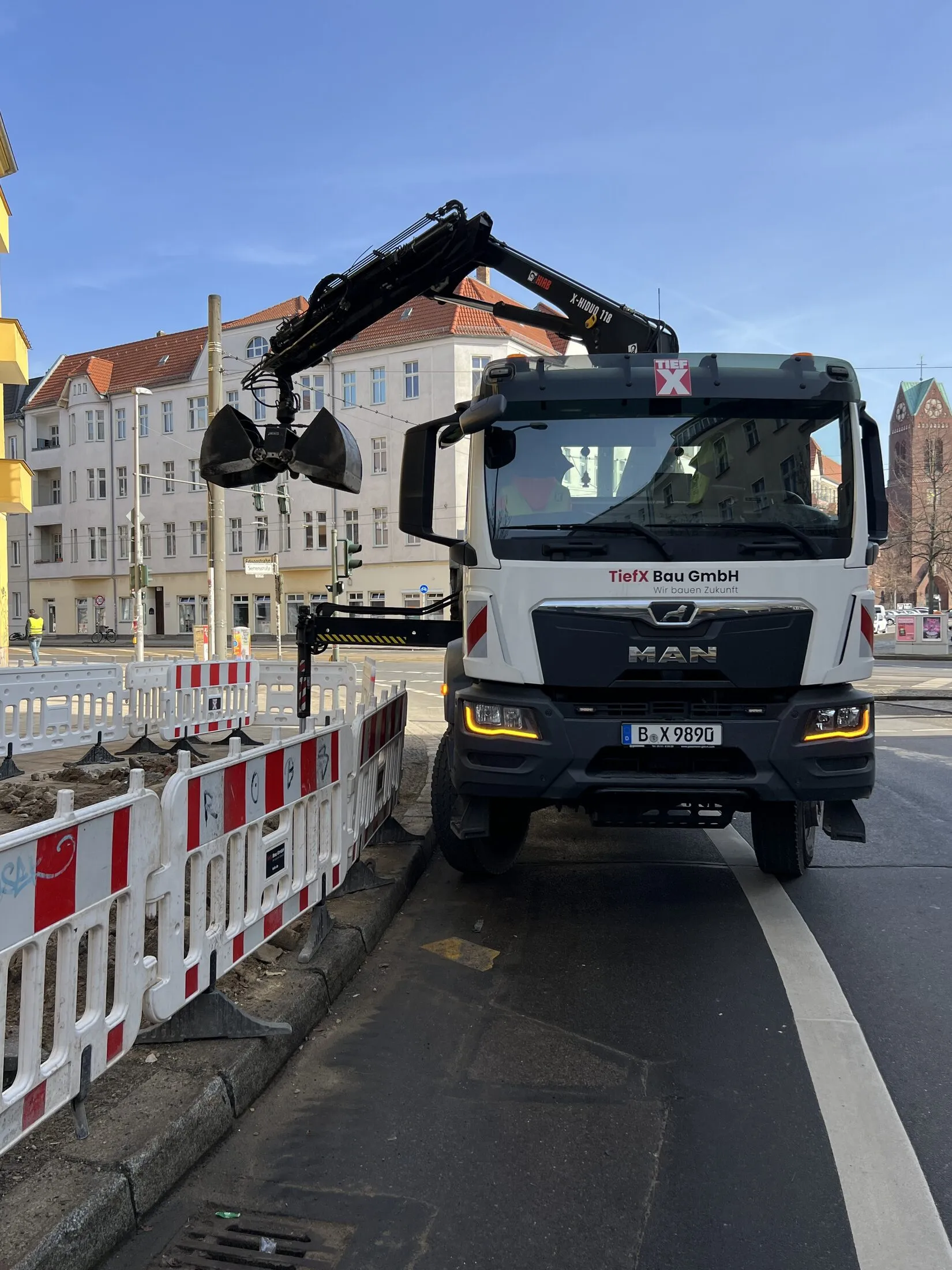 3-Seiten-Kipper mit ausgefahrenem Ladekran der TiefX Bau GmbH