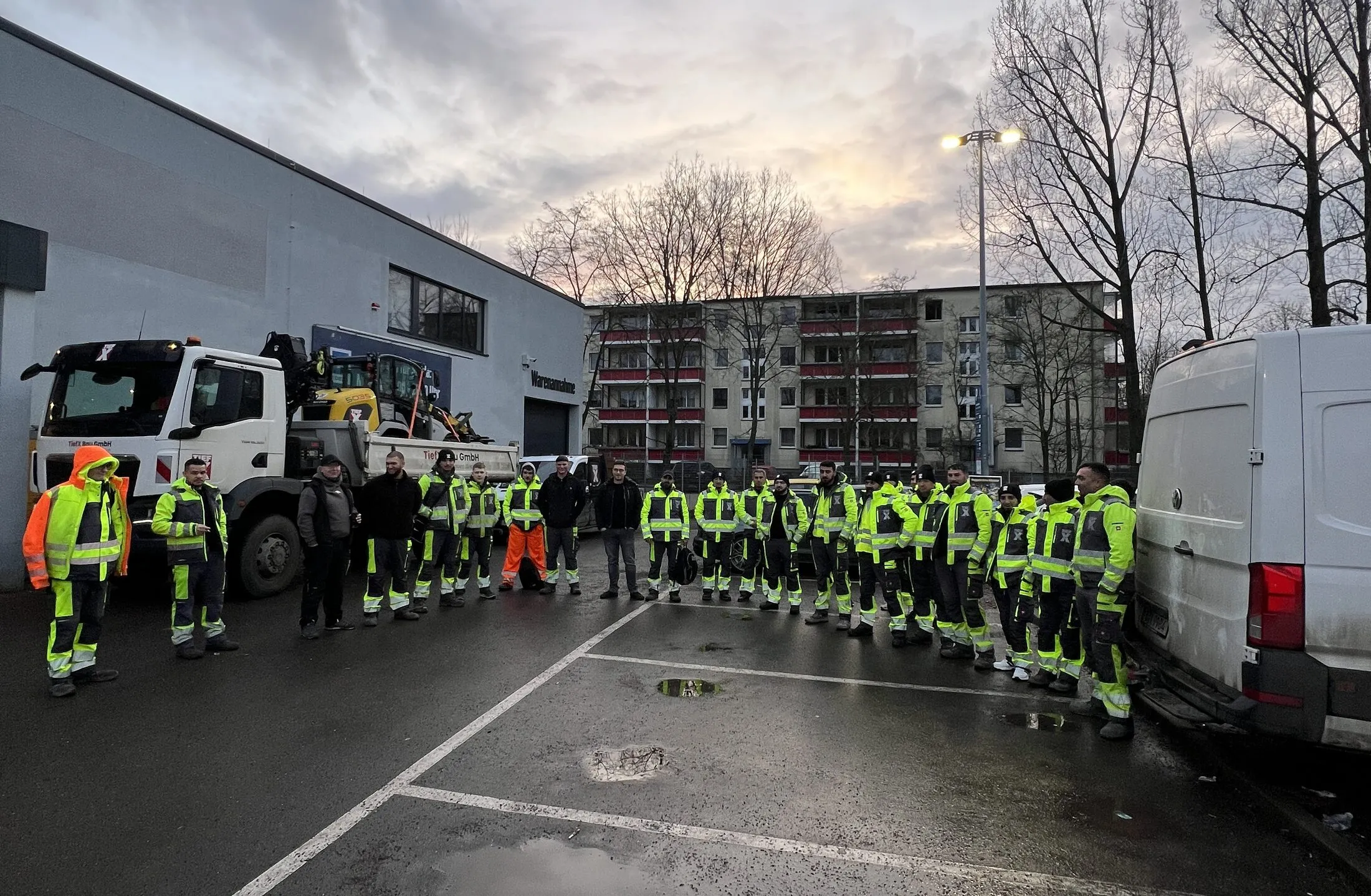 Team der TiefX Bau GmbH mit Bauhelmen auf der Baustelle
